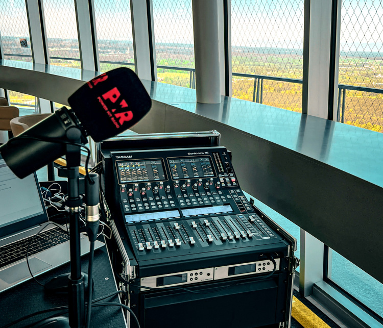 View over the Sonicview 16 user interface at the landscape around Vilnius. In the foreground is a microphone with a windscreen.